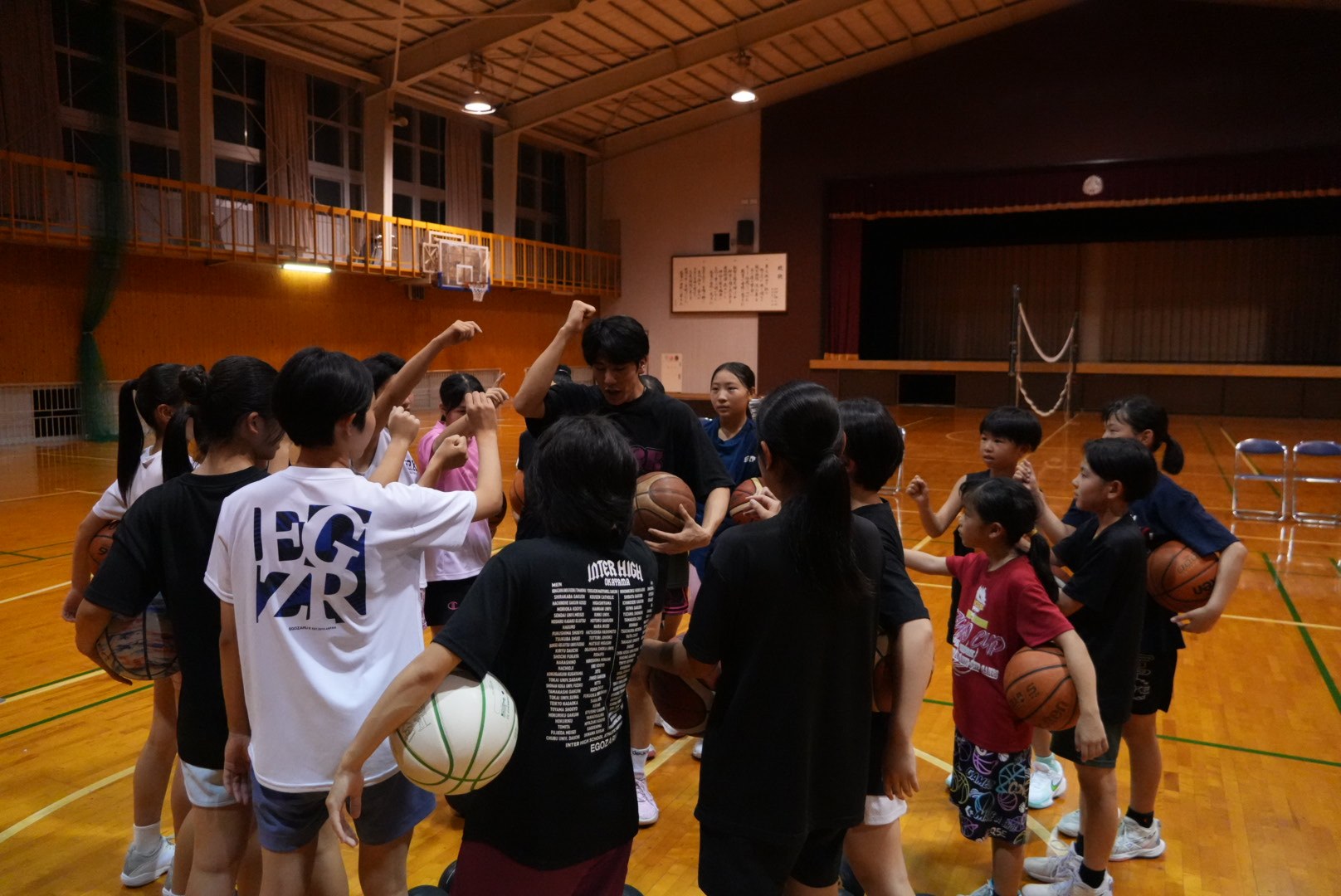 ボールを持って円陣を組む選手とコーチ